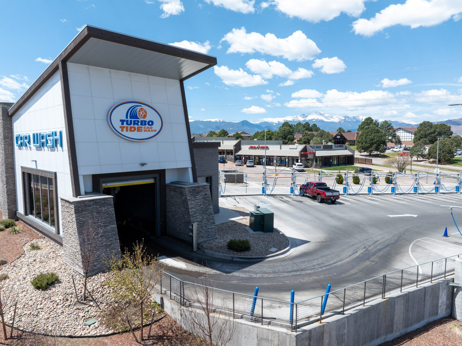 Oblique aerial view of a commercial building with the snow-capped Rampart Range spanning the background, Colorado Springs