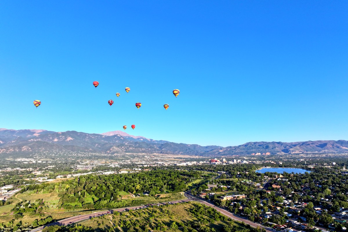 Hot air balloons over Colorado Springs with Pikes Peak and Garden of the Gods visible
