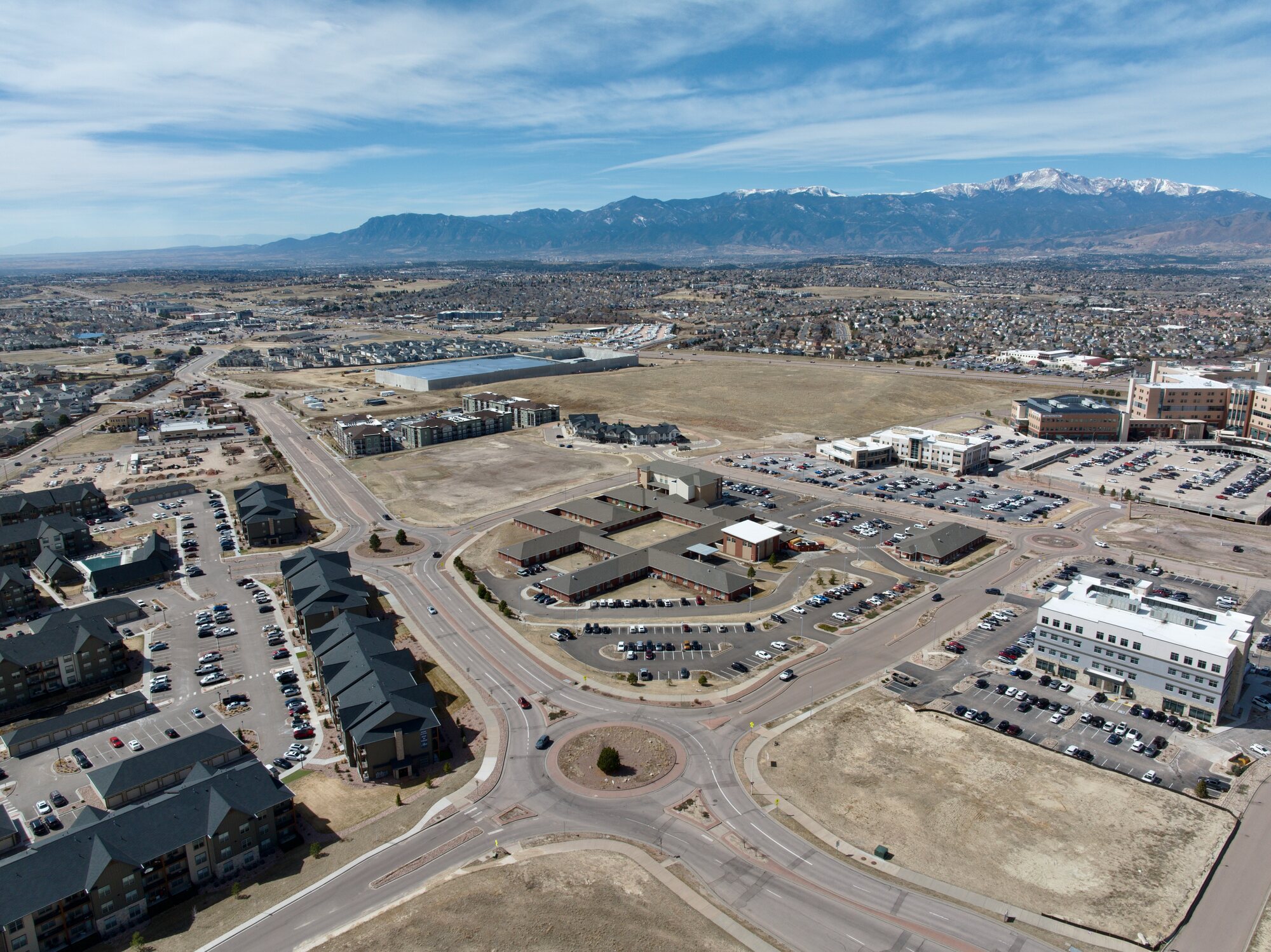 Aerial view of Colorado Springs area with Pikes Peak backdrop — residential and commercial properties visible